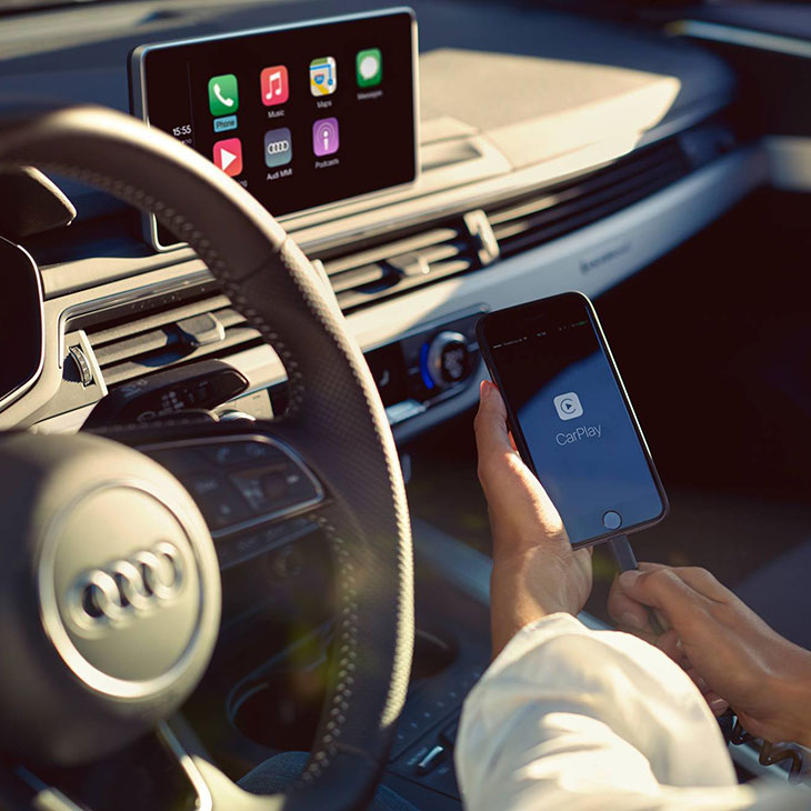 Frau bedient Smartphone Interface in Ihrem Audi