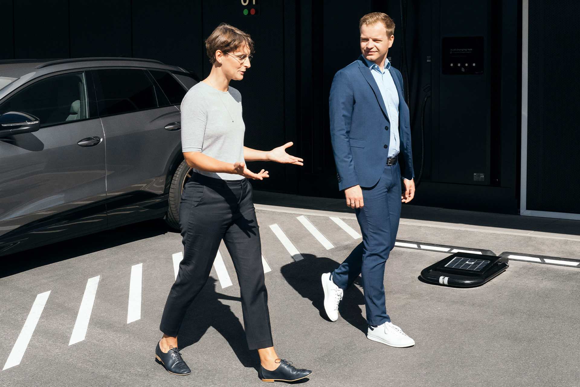 Les experts en développement durable Dr Johanna Klewitz et Malte Vömel traversent le parking devant le Audi charging hub à Nuremberg.