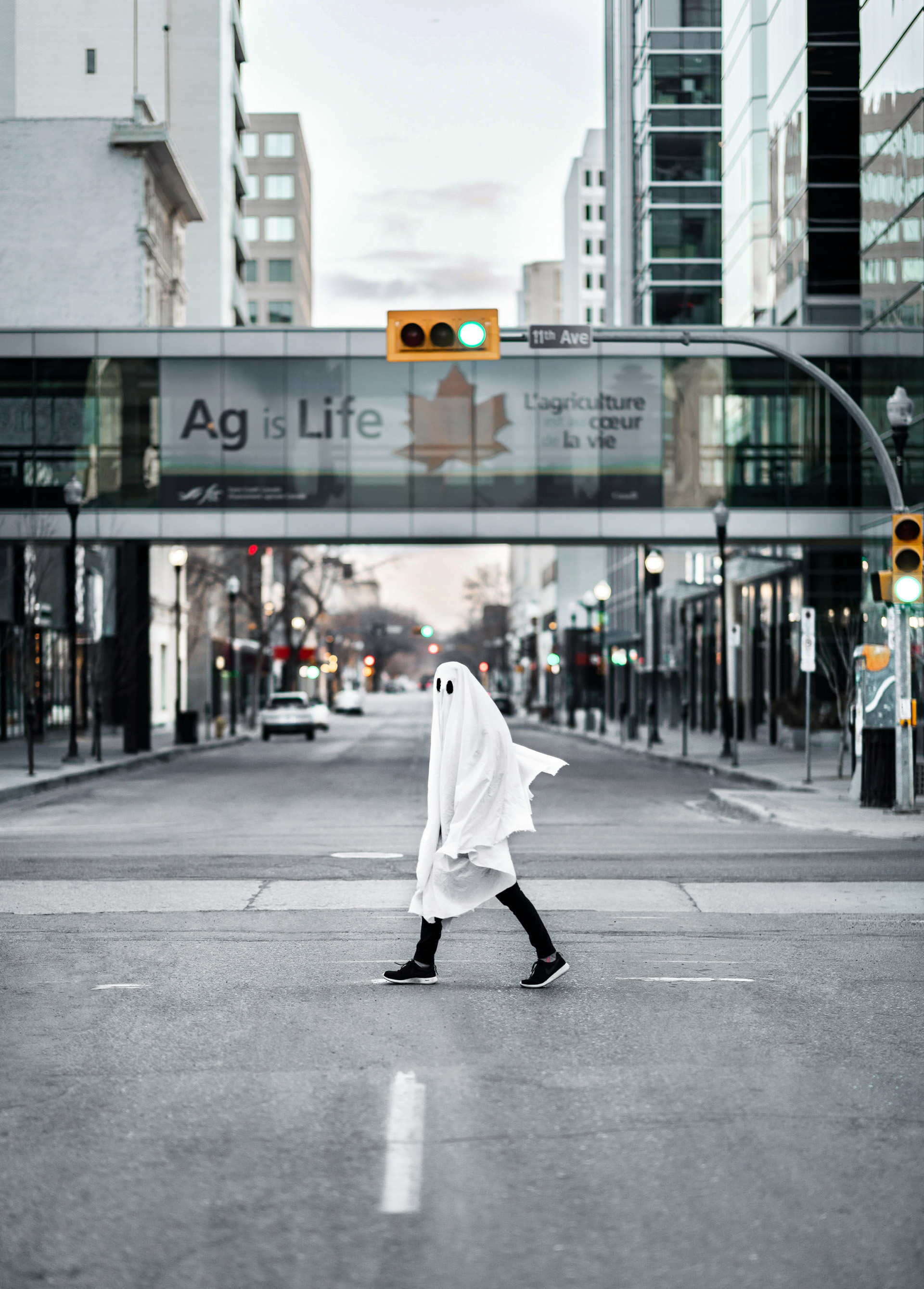 Una persona vestita da fantasma cammina per strada.