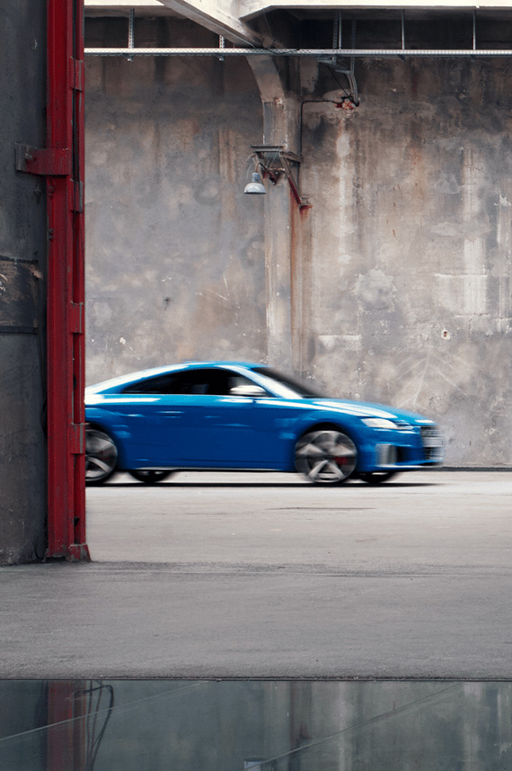 Audi TTS Coupé floue à l’arrière-plan d’un hall d’usine 